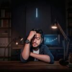 A man sitting at a desk in a dark room